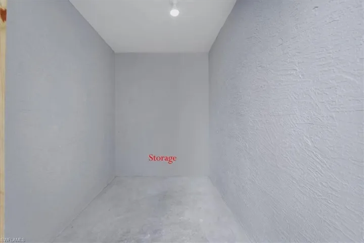 Unfurnished room with a textured wall and unfinished concrete floors
