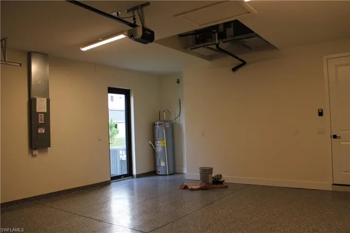 Garage featuring an epoxy-coated concrete floor, a side entry door with clear glass, a ceiling-mounted garage door opener, and interior access door