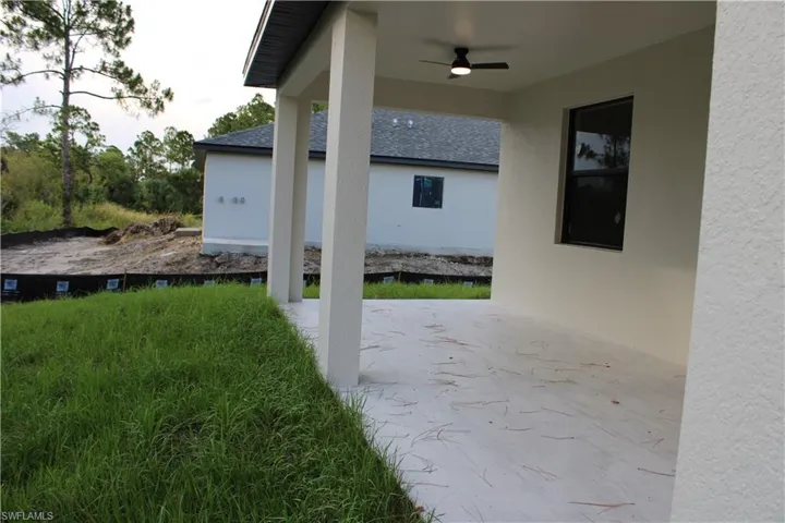 Covered patio with a mounted ceiling fan, concrete flooring, and a stucco exterior