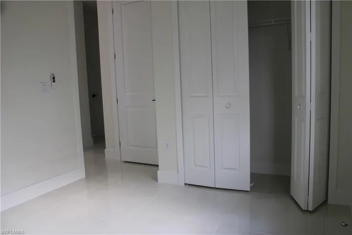 White bi-fold closet doors with round hardware, featuring a wire shelving system