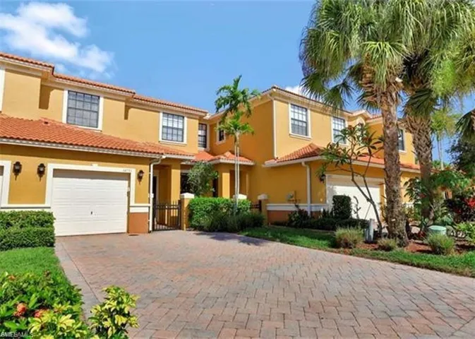Mediterranean / spanish house featuring a tile roof, decorative driveway, stucco siding, and an attached garage