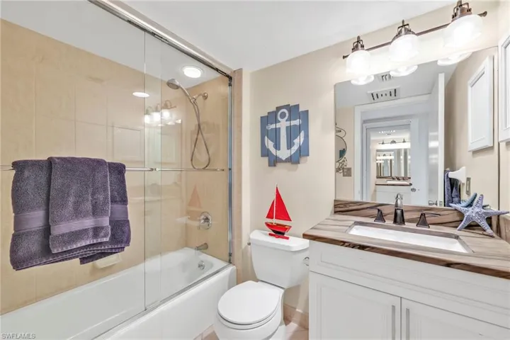 Bathroom featuring enclosed tub / shower combo and vanity