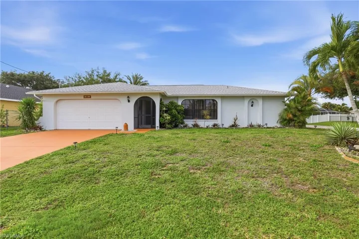 Ranch-style house featuring a garage, stucco siding, concrete driveway, and a front yard