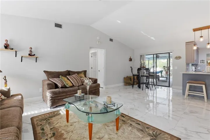Living room with a high ceiling and light marble finish floors