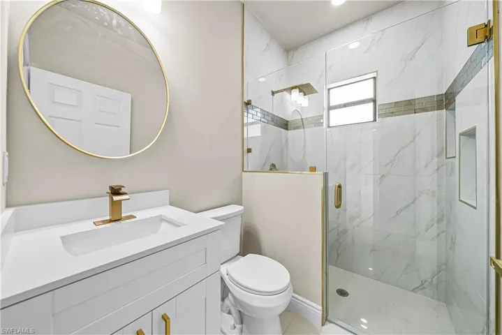 Full bath featuring vanity and a marble finish shower