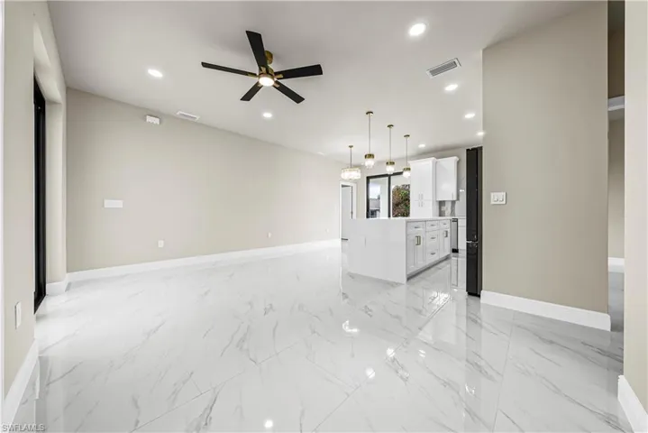 Unfurnished room featuring ceiling fan, light marble finish floors, and recessed lighting