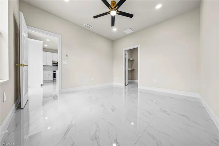 Empty room with light marble finish floors, recessed lighting, and ceiling fan
