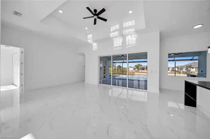 Unfurnished living room featuring a ceiling fan, recessed lighting, and visible vents