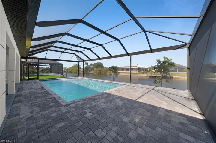 Pool with a lanai, a water view, and a patio area