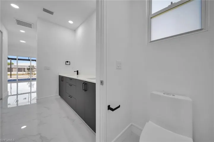 Full bath featuring visible vents, recessed lighting, marble finish floor, and baseboards