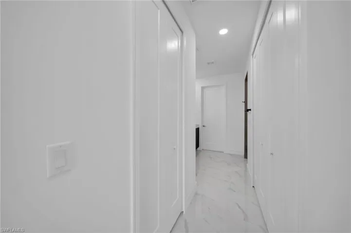 Hall featuring recessed lighting, marble finish floor, and baseboards