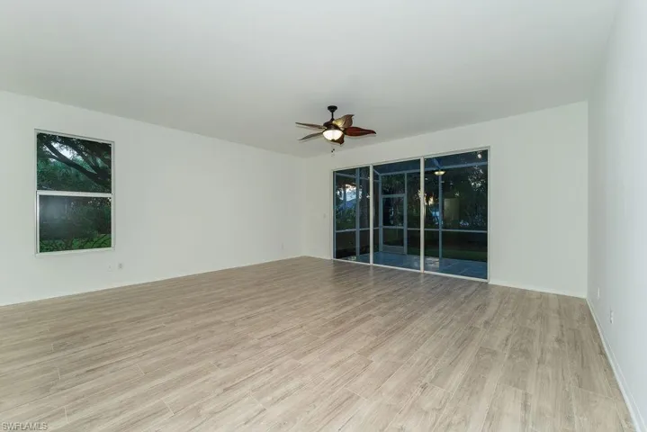 Unfurnished room featuring a ceiling fan, light wood finished floors, and a sunroom