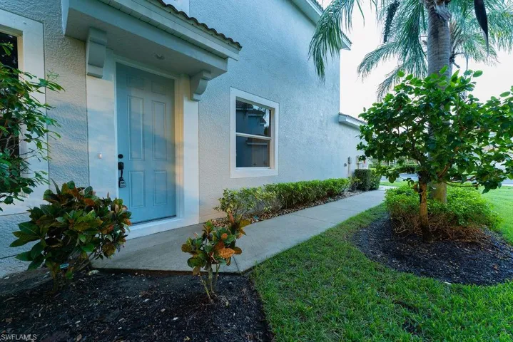 Entrance to property featuring stucco siding and a yard