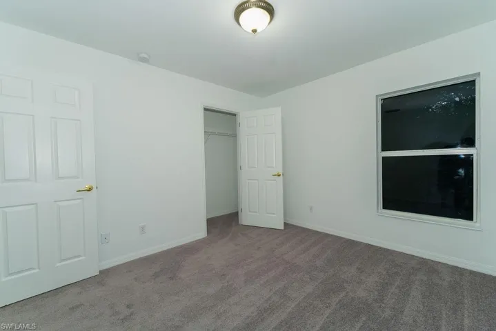 Unfurnished bedroom with carpet floors and a spacious closet