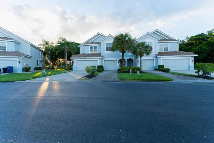 View of front of house with stucco siding, driveway, and a garage
