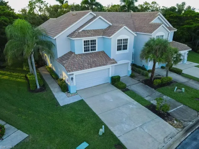 View of front of property featuring a front yard, concrete driveway, stucco siding, and an attached garage