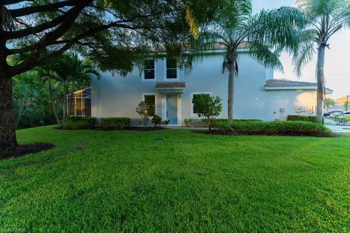 Mediterranean / spanish home featuring glass enclosure, a front yard, stucco siding, and a tile roof
