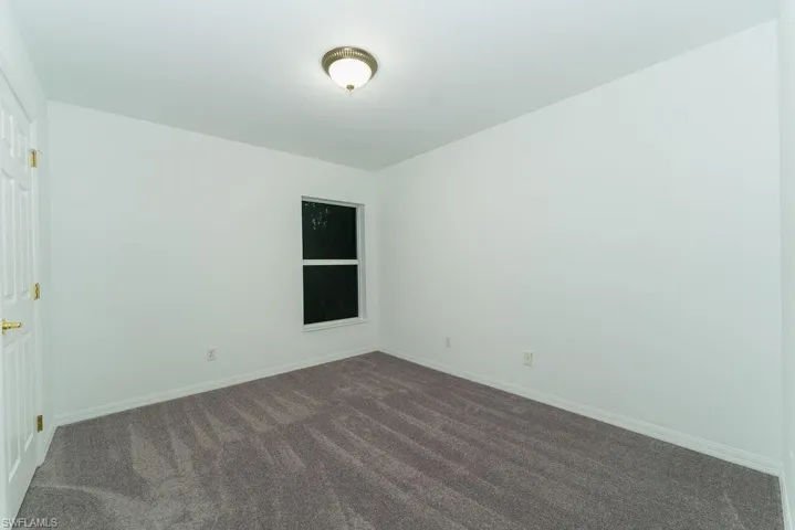 Carpeted empty room featuring baseboards