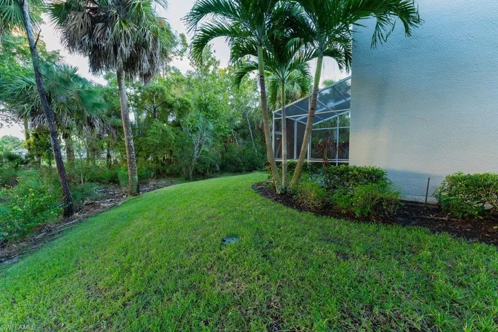 View of grassy yard with glass enclosure