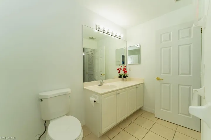 Half bathroom featuring light tile patterned floors and vanity