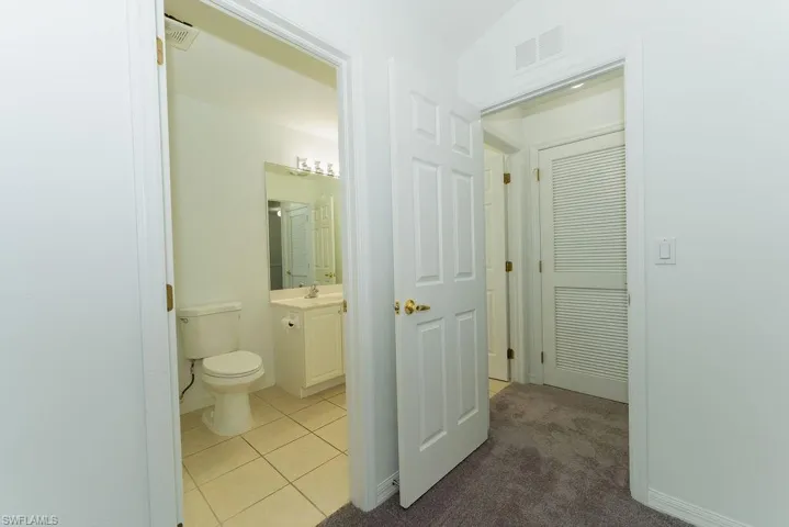Bathroom with vanity, tile patterned flooring, and carpet