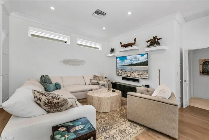 Living room with light hardwood / wood-style flooring and crown molding