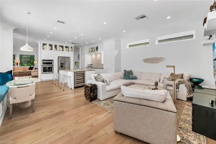 Living room with crown molding, French oak flooring, and wine cooler