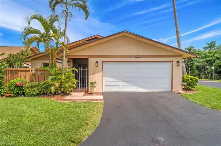 Single story home featuring a garage and a front lawn