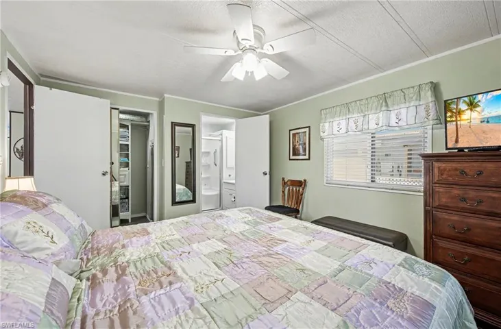 Bedroom with crown molding, a ceiling fan, and connected bathroom