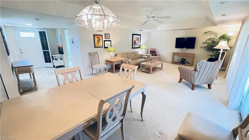 Living/Dining combo with light carpet, hanging lights, and ceiling fan