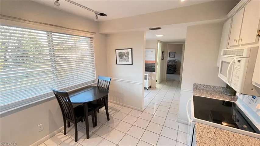 Eat-in Kitchen with light tile patterned floors and track lighting.