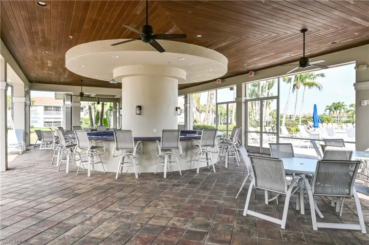 Covered outdoor bar area featuring a wood-finish ceiling with integrated fans and recessed lighting