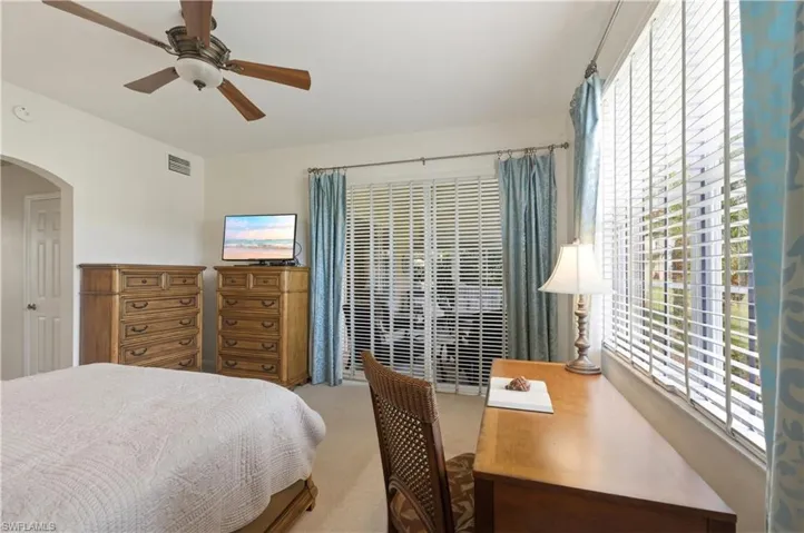 Bright room with neutral wall paint and carpeting, featuring a ceiling fan with integrated lighting