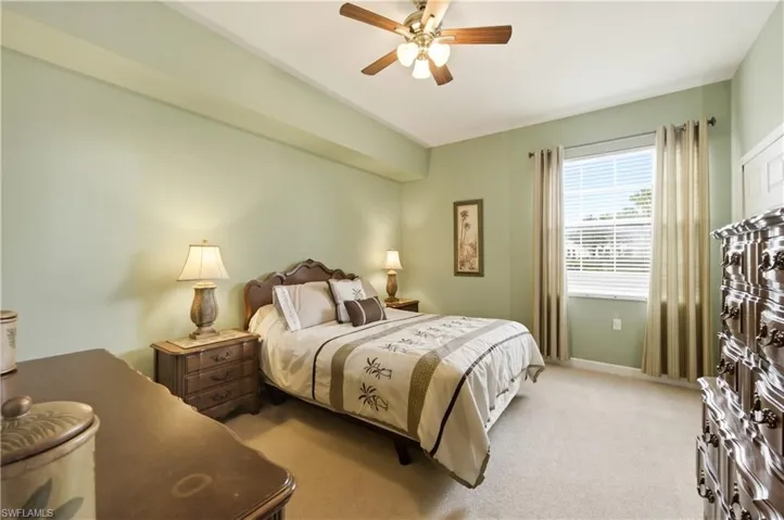 Carpeted bedroom featuring a ceiling fan, a window with blinds and drapes, and a white paneled door
