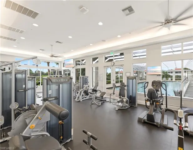 Fitness center featuring rubberized flooring, abundant natural light, recessed lighting, ceiling fans, and a variety of exercise equipment