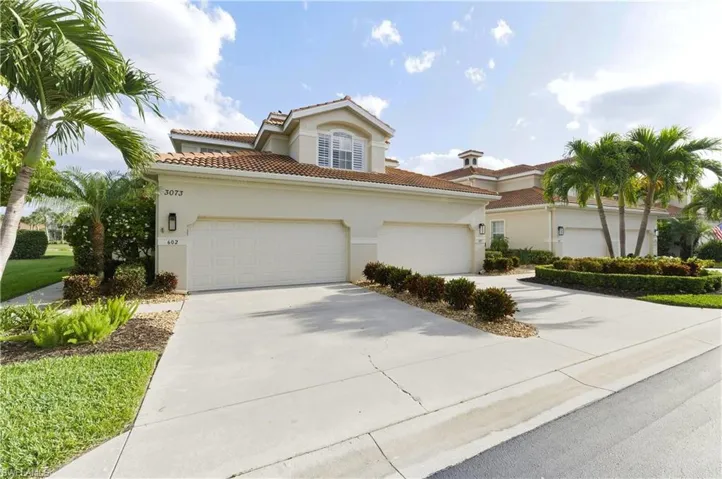 Mediterranean-style architecture with a tile roof, light-toned exterior, and integrated double garage