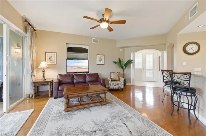 Living area featuring wood-finish flooring, a ceiling fan, and sliding glass doors to the exterior