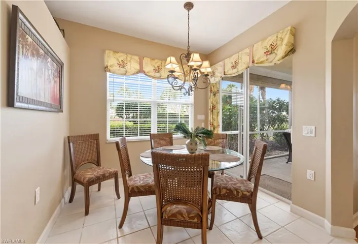 Dining area featuring tile flooring, a window with horizontal blinds, and a sliding glass door providing access to an outdoor area
