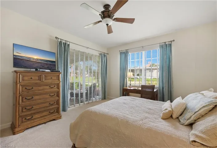 Bedroom featuring a ceiling fan with integrated lighting, soft carpet flooring, and neutral wall tones