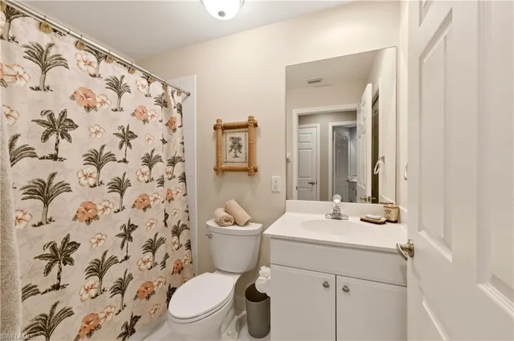 Bathroom featuring a white vanity with an integrated sink, polished chrome faucet, and a large wall-mounted mirror