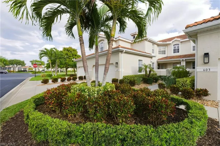 Lush landscaping featuring sculpted hedges and mature palm trees