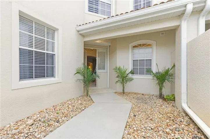 Stucco exterior featuring multiple windows with integrated blinds