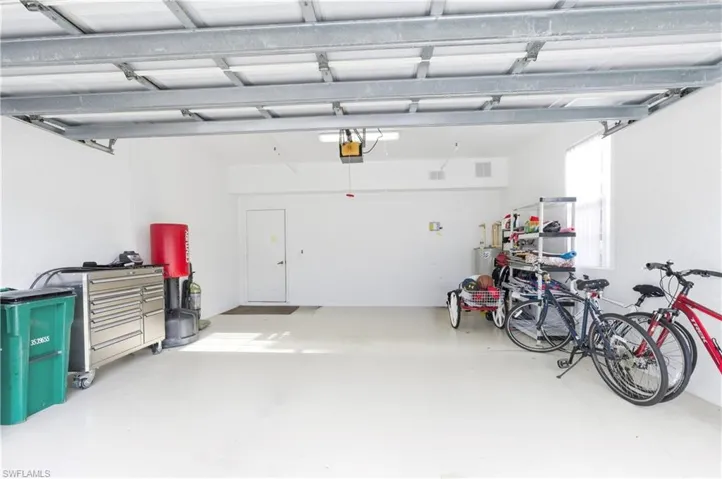 Spacious two-car garage featuring a white interior and light-colored flooring