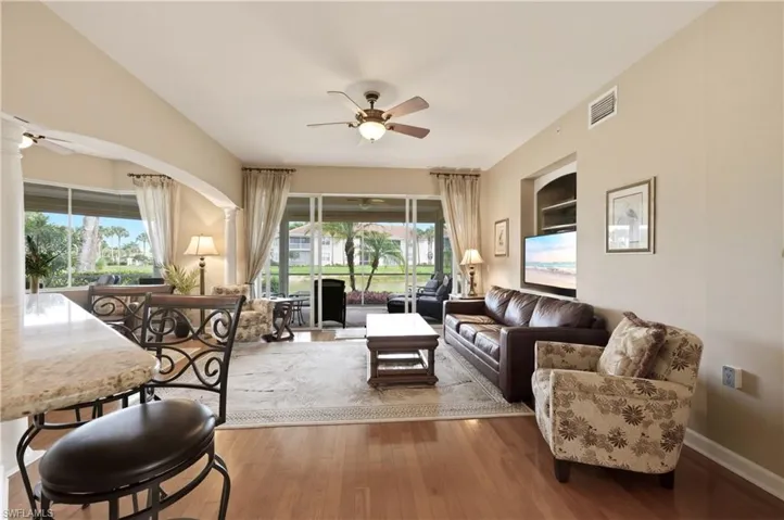 Expansive living area with wood-finish flooring, a ceiling fan, and recessed lighting
