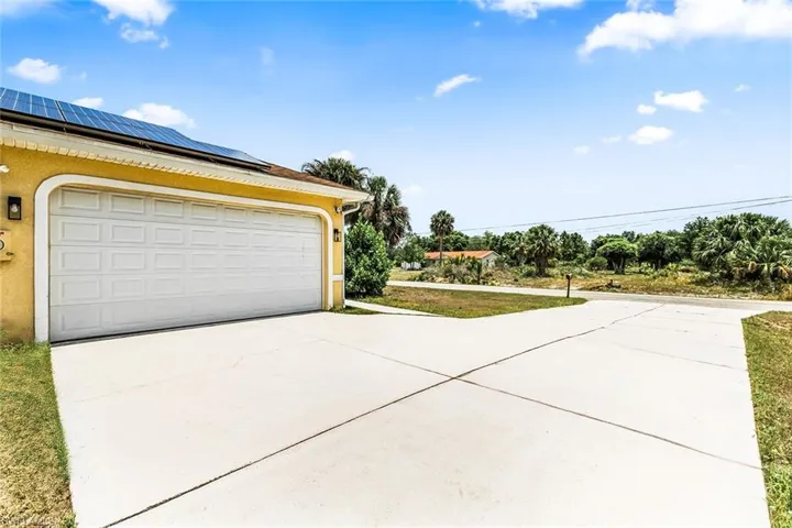 Garage with roof mounted solar panels and driveway