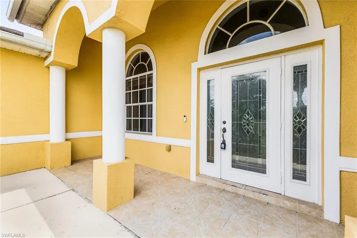 Doorway to property featuring stucco siding and french doors