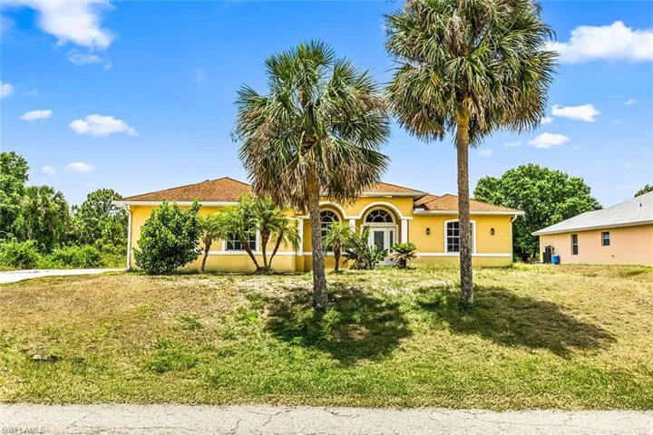 Mediterranean / spanish-style home with a front yard and stucco siding