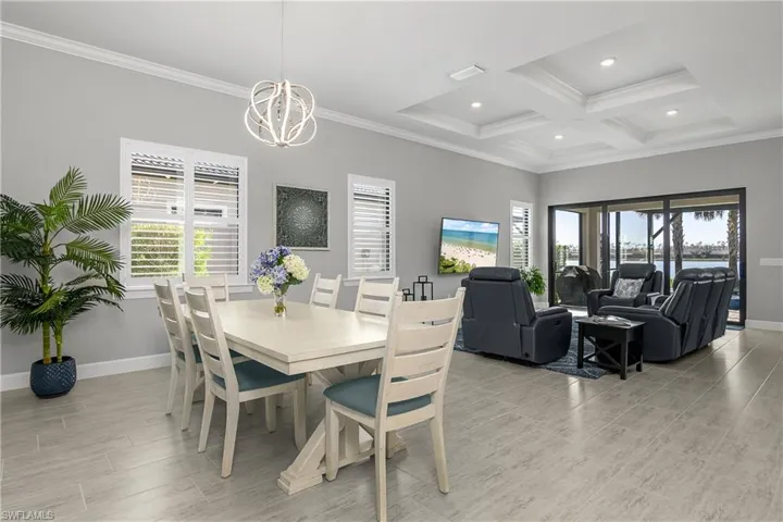 Open floor plan with lots of natural light. Note the plantation shutters, tray ceiling, and crown molding.