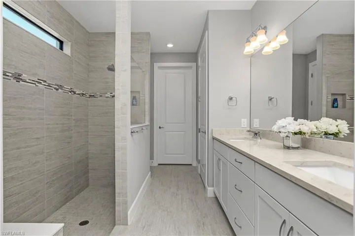 Primary ensuite bath with oversized walk-in shower, dual sinks, private water closet, linen closet, and spacious walk-in closet.