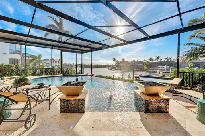 The entry to this saltwater oasis is flanked by two fire bowls as you step onto the sunshelf and captures the view of the intersecting canals & preserve.